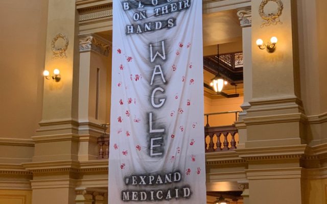 Banners calling out legislative leaders hang briefly in Statehouse